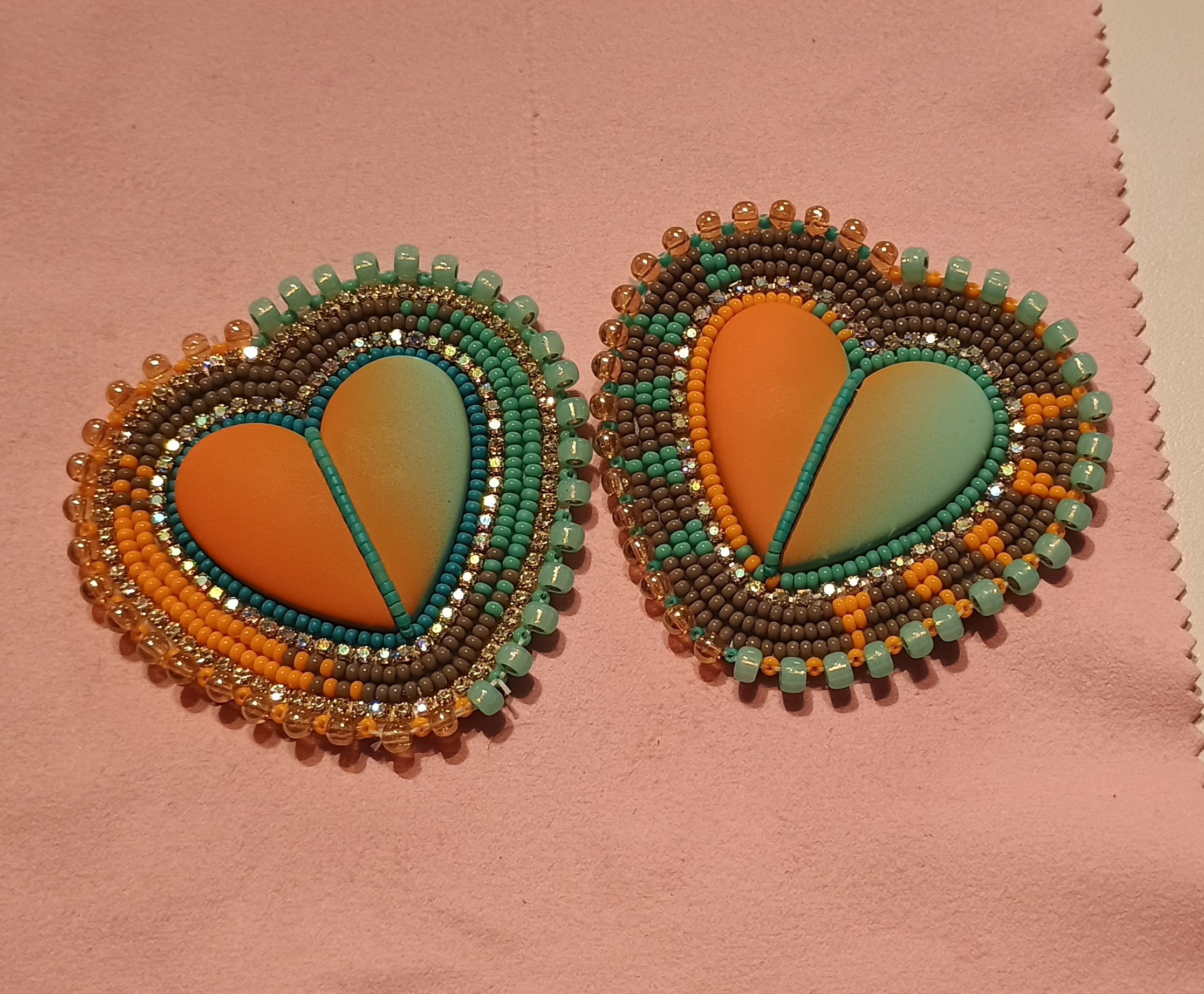 a-symmetrical blue and orange hearts with a beaded grey border and coloured spikes